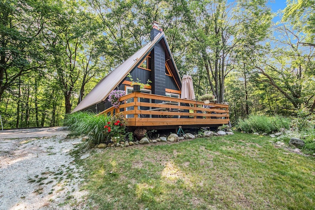 rear view of property featuring a yard and a deck