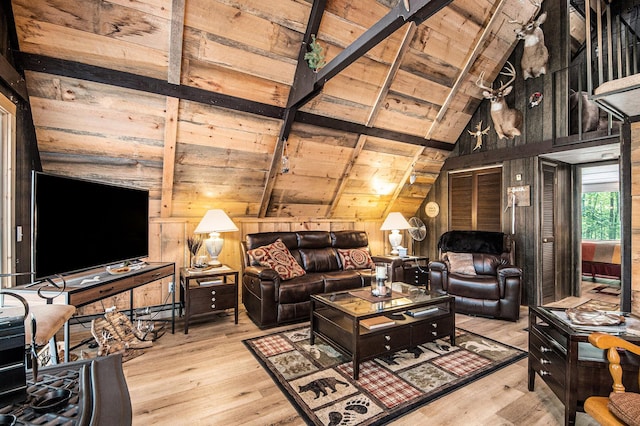 living room featuring vaulted ceiling with beams, wooden ceiling, wooden walls, and light wood-type flooring