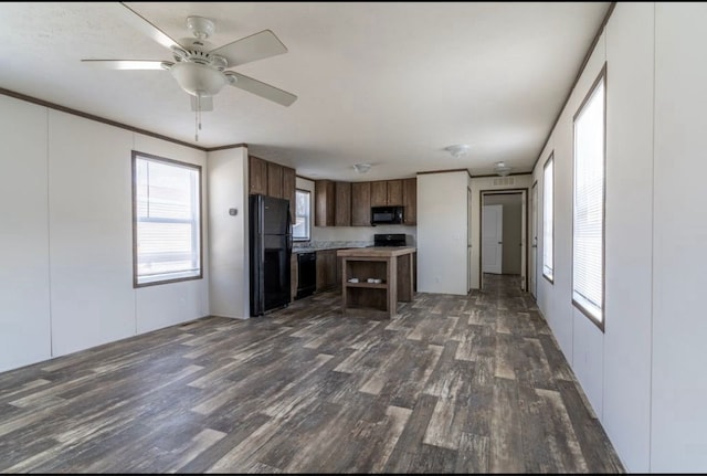 kitchen with dark hardwood / wood-style flooring, ornamental molding, a center island, ceiling fan, and black appliances