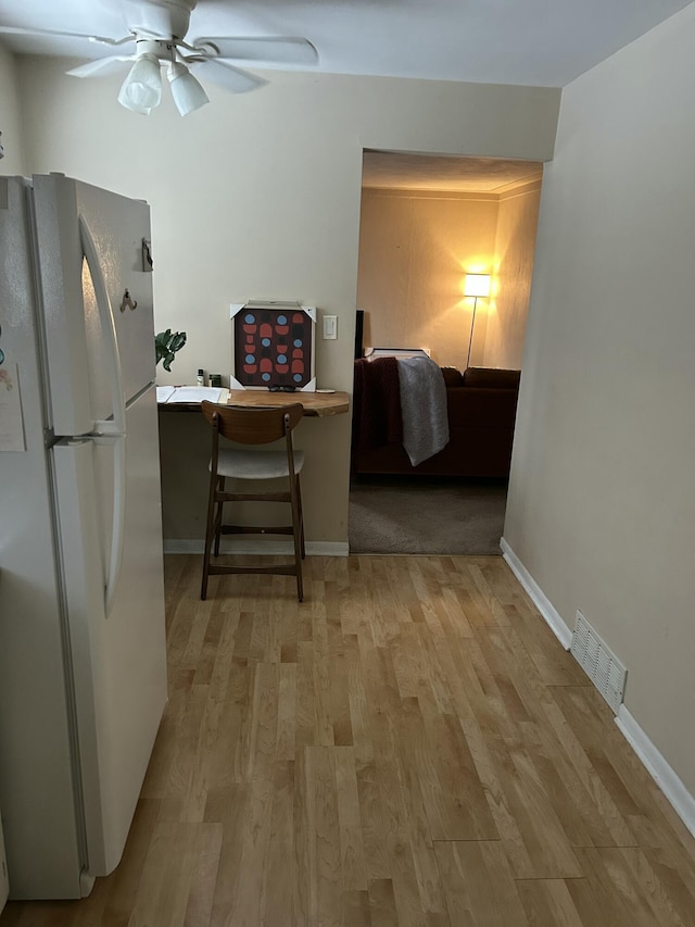 kitchen featuring ceiling fan, white fridge, and light hardwood / wood-style flooring