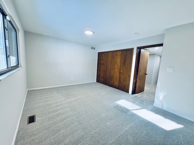 unfurnished bedroom featuring a closet and light carpet