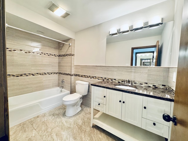 full bathroom featuring tile walls, vanity, decorative backsplash, toilet, and tiled shower / bath