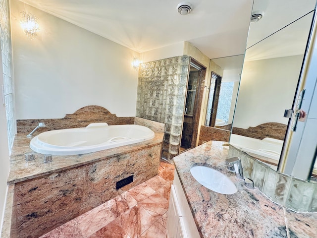 bathroom featuring tiled tub and vanity