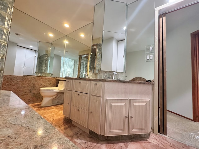 bathroom featuring tasteful backsplash, vanity, and toilet