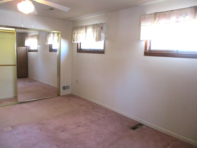 unfurnished bedroom with a closet, ceiling fan, and carpet flooring