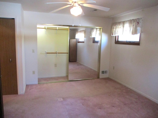 unfurnished bedroom with ceiling fan, light colored carpet, and a closet