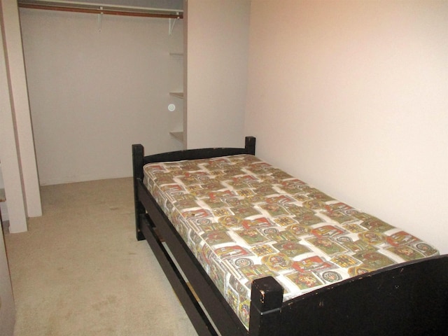 bedroom featuring light colored carpet and a closet