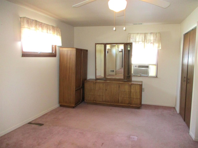 unfurnished bedroom featuring a closet, light colored carpet, ceiling fan, and cooling unit