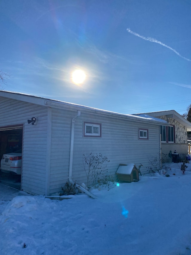 view of snowy exterior featuring a garage