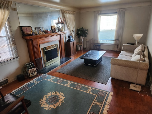 living room with a high end fireplace and dark hardwood / wood-style floors