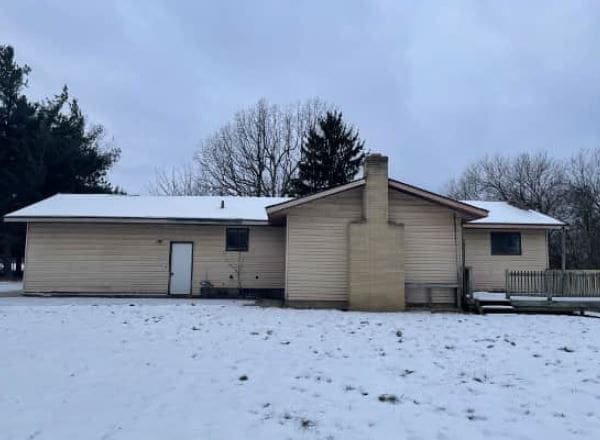 view of snow covered rear of property