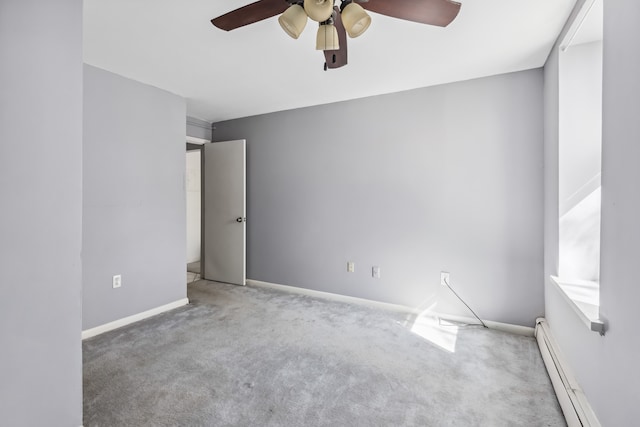 unfurnished room featuring plenty of natural light, a baseboard radiator, ceiling fan, and carpet flooring