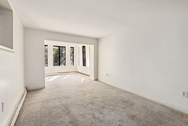 empty room featuring a baseboard radiator and light colored carpet