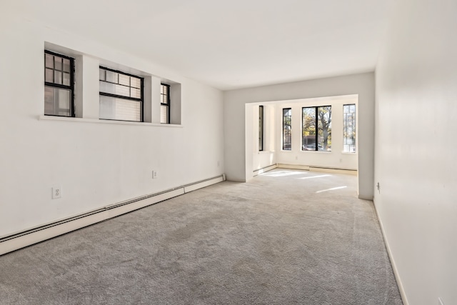 empty room featuring baseboard heating and light carpet