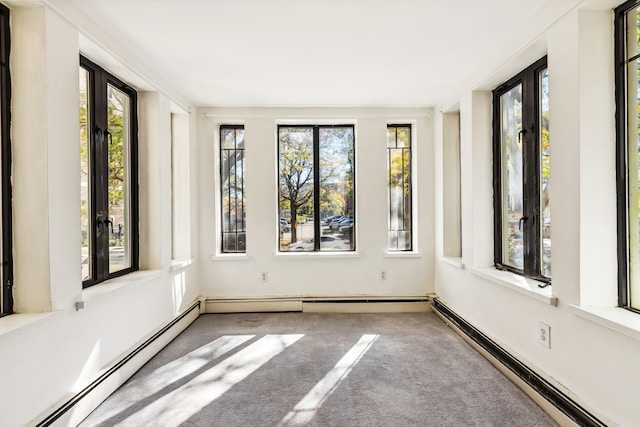 unfurnished sunroom with a baseboard heating unit