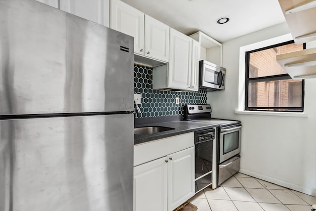 kitchen with white cabinetry, appliances with stainless steel finishes, light tile patterned flooring, and backsplash