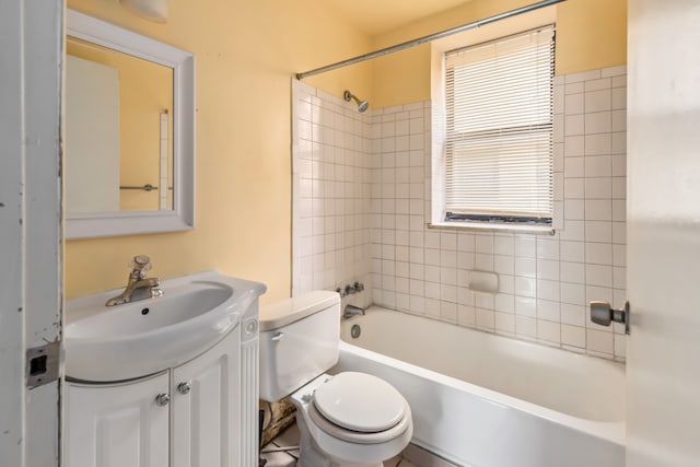 full bathroom with tiled shower / bath, vanity, and toilet