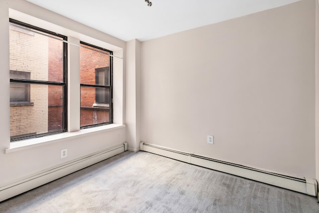 carpeted empty room featuring a baseboard heating unit