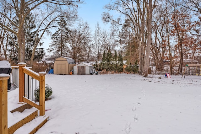 yard covered in snow featuring a shed