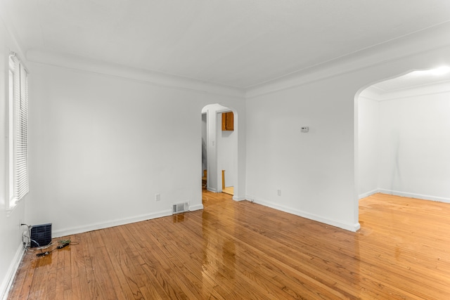 spare room with ornamental molding and hardwood / wood-style floors