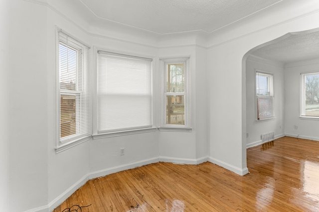 unfurnished room featuring light hardwood / wood-style flooring and a textured ceiling