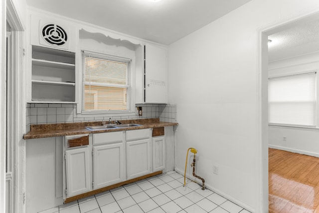 kitchen featuring sink, decorative backsplash, a wealth of natural light, and white cabinets