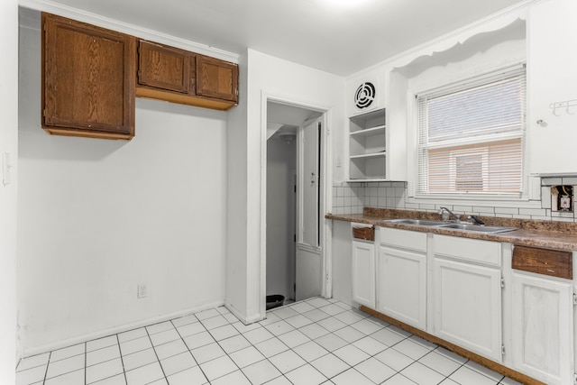 kitchen featuring white cabinets, sink, and backsplash