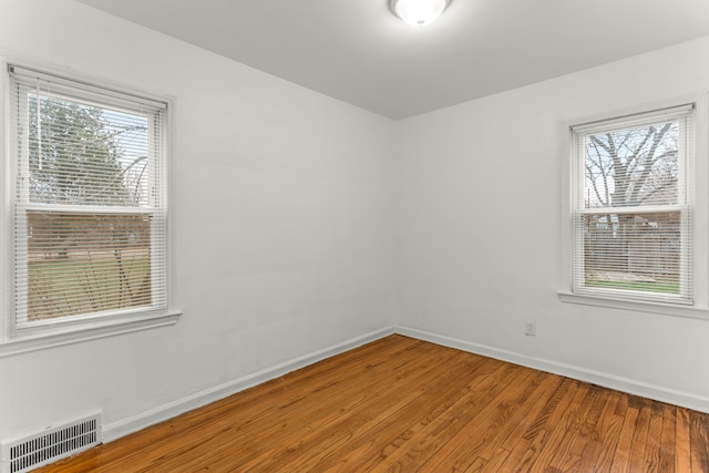 empty room with wood-type flooring and a wealth of natural light