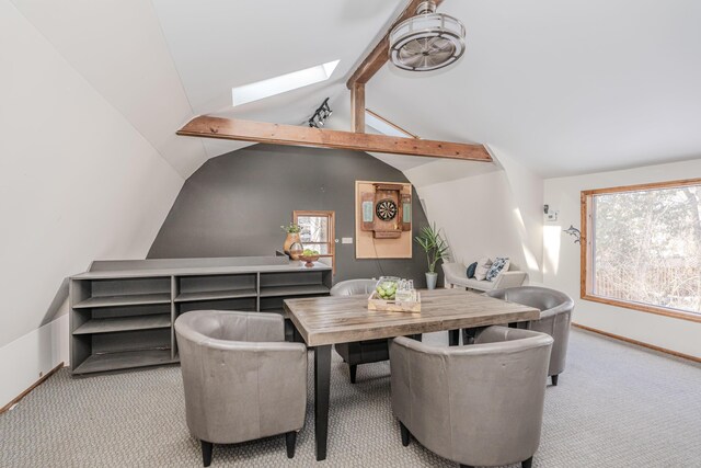 carpeted dining area with lofted ceiling with skylight and a healthy amount of sunlight