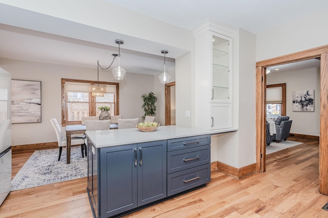 kitchen featuring decorative light fixtures, a wealth of natural light, and light wood-type flooring