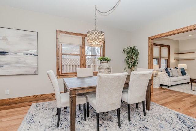 dining space with hardwood / wood-style flooring and a chandelier