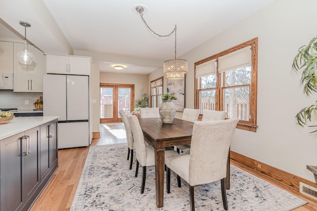 dining space with a notable chandelier and light wood-type flooring