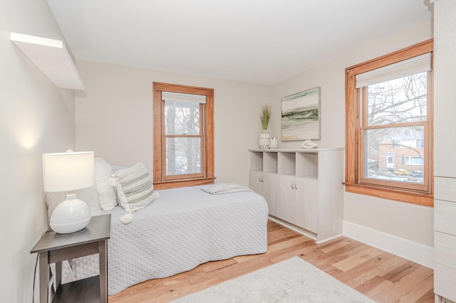 bedroom with light hardwood / wood-style floors and multiple windows