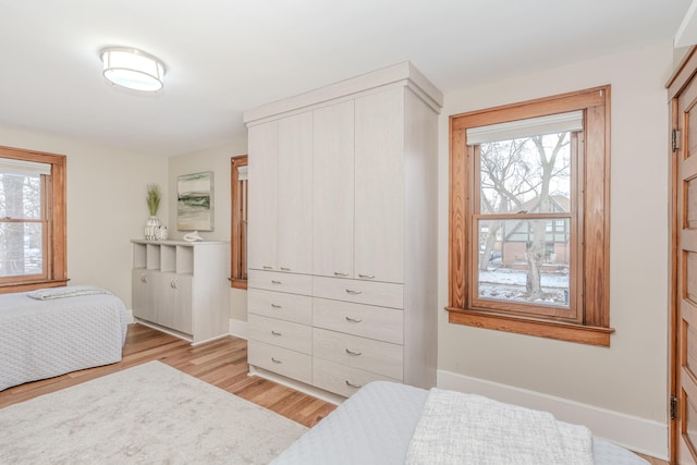 bedroom with multiple windows and light hardwood / wood-style flooring