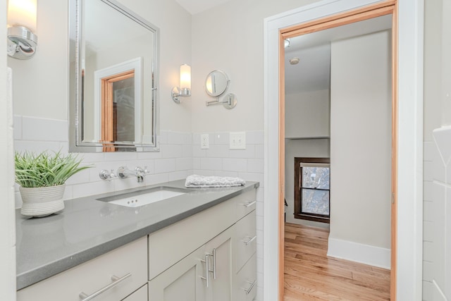 bathroom featuring vanity, hardwood / wood-style floors, and tile walls