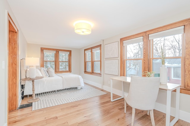 bedroom with multiple windows and light hardwood / wood-style flooring