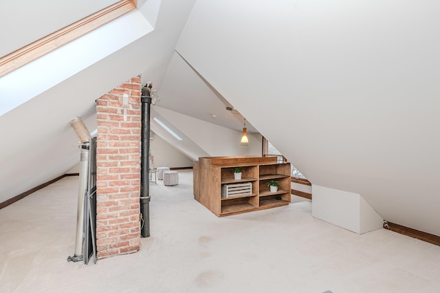 additional living space featuring light carpet and lofted ceiling with skylight