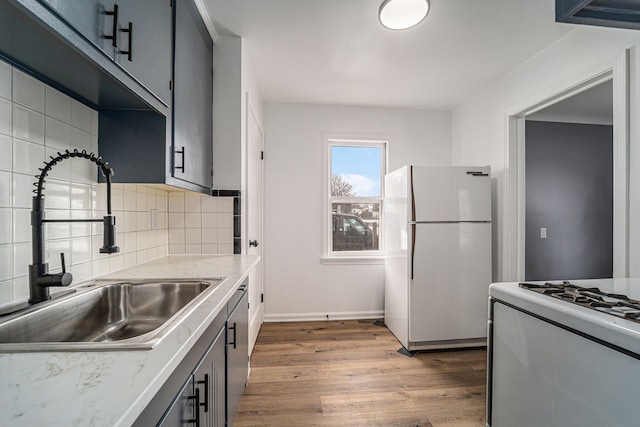 kitchen featuring sink, gray cabinetry, backsplash, dark hardwood / wood-style floors, and white fridge