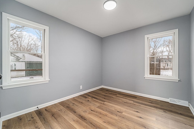 spare room featuring hardwood / wood-style flooring and plenty of natural light