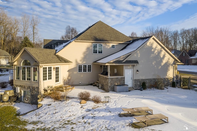 view of snow covered back of property