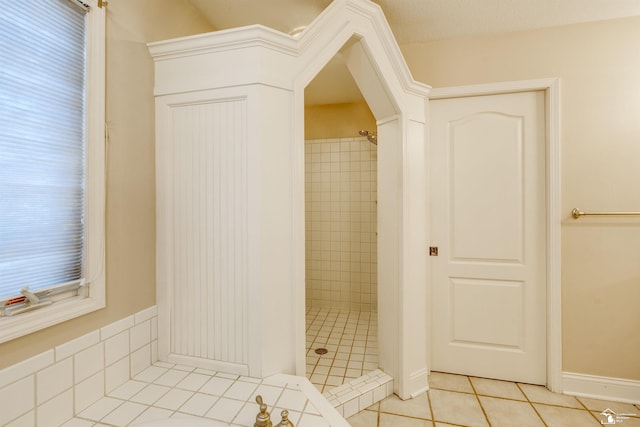 bathroom with tiled shower and tile patterned floors