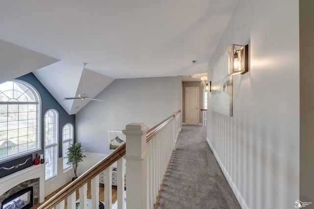 hallway featuring lofted ceiling and carpet flooring