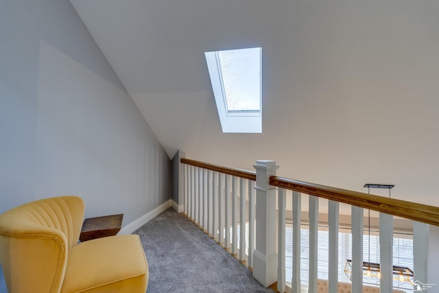 sitting room with a water view, carpet, and vaulted ceiling with skylight