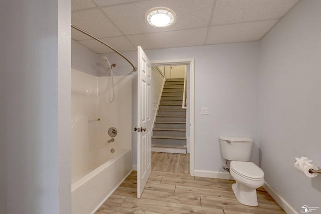 bathroom with toilet, tub / shower combination, and a drop ceiling