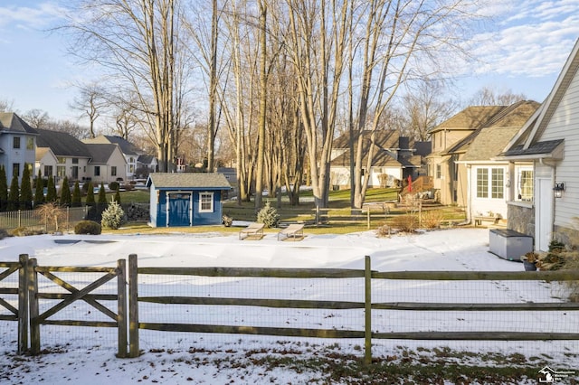 snowy yard with a storage shed