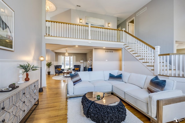 living room with light hardwood / wood-style floors and a high ceiling