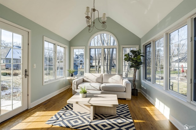 sunroom with a notable chandelier, plenty of natural light, and vaulted ceiling