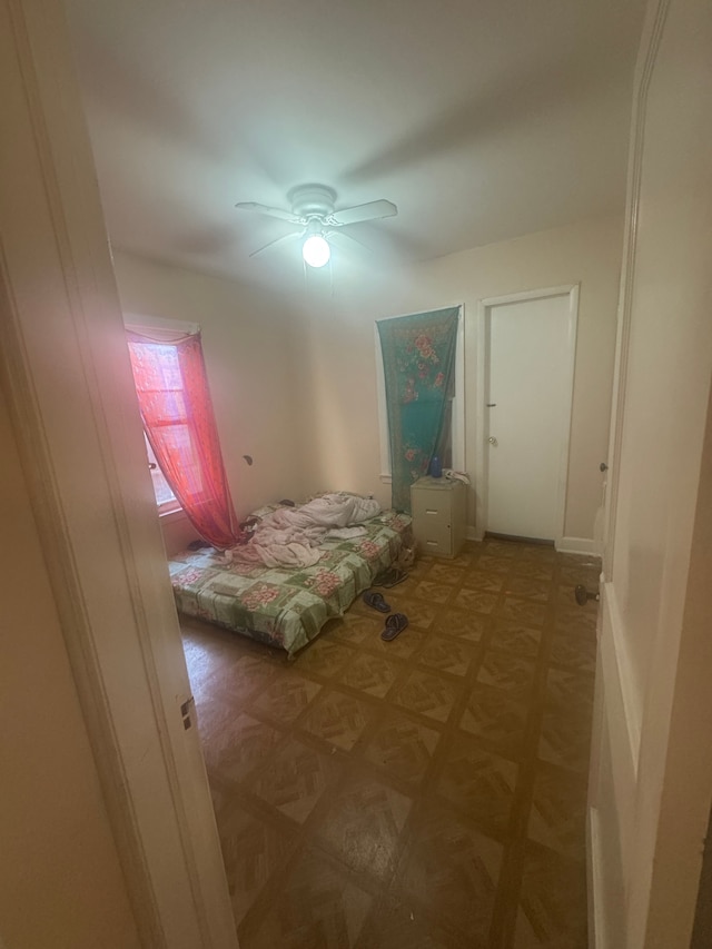 unfurnished bedroom featuring dark parquet flooring and ceiling fan