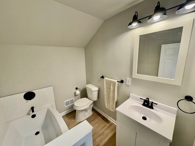 bathroom featuring hardwood / wood-style flooring, vanity, a bath, vaulted ceiling, and toilet