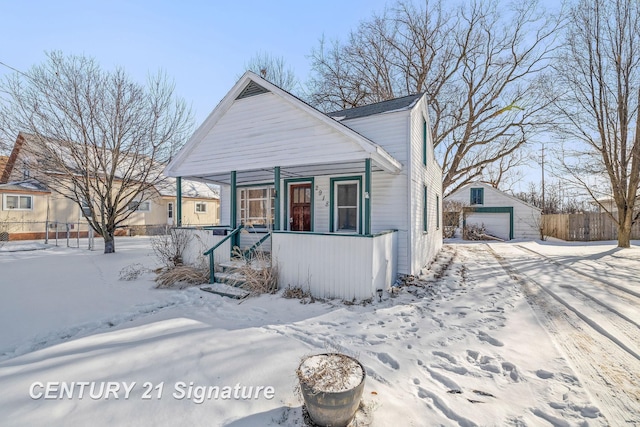 view of front facade featuring a garage, an outbuilding, and covered porch